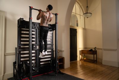 Man doing a pull up on a high bar
