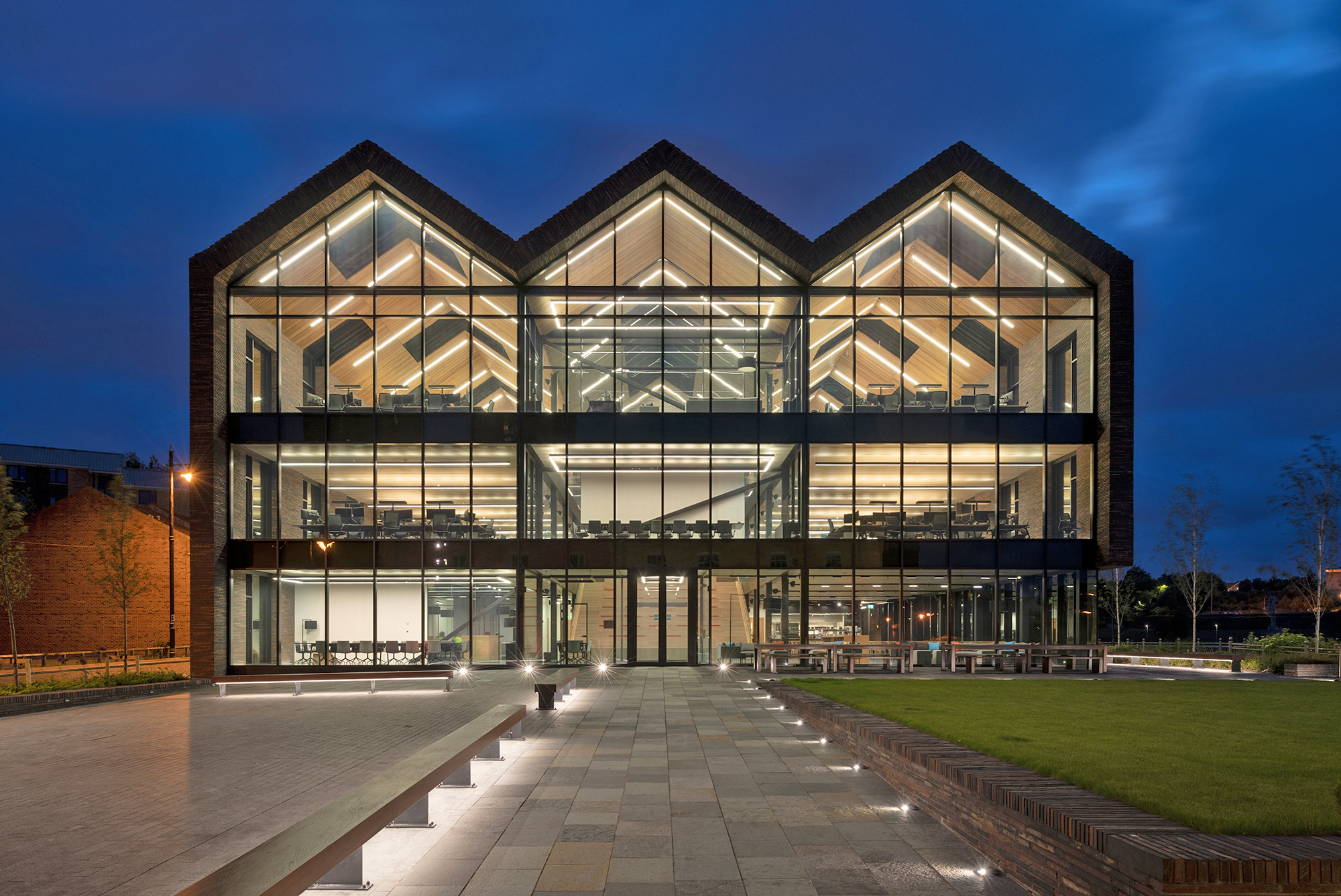 Large glass-fronted building. Three peaked building similar to terraced house