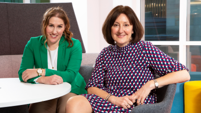 Two women sat smiling at camera