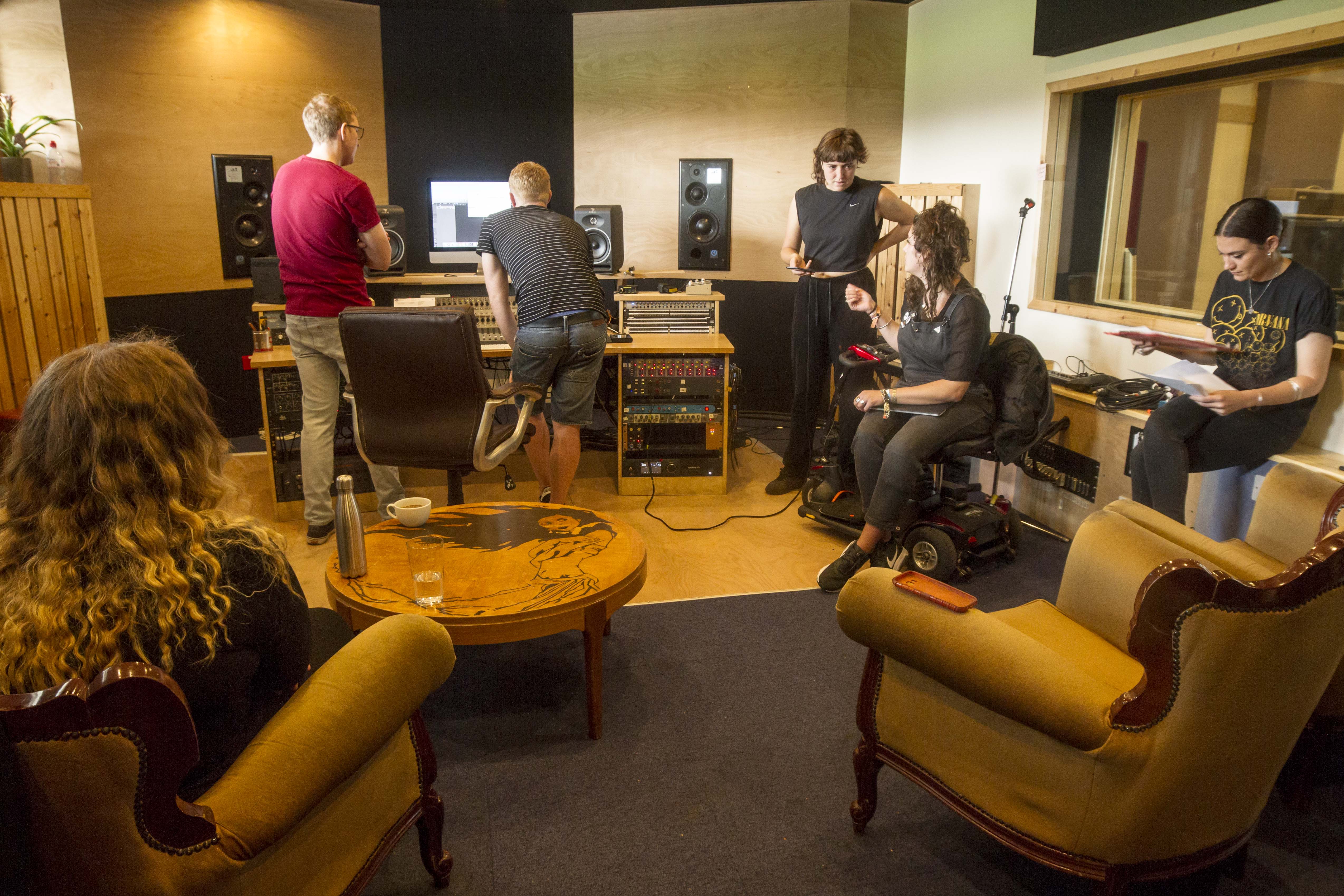 Team of six people working in a music studio