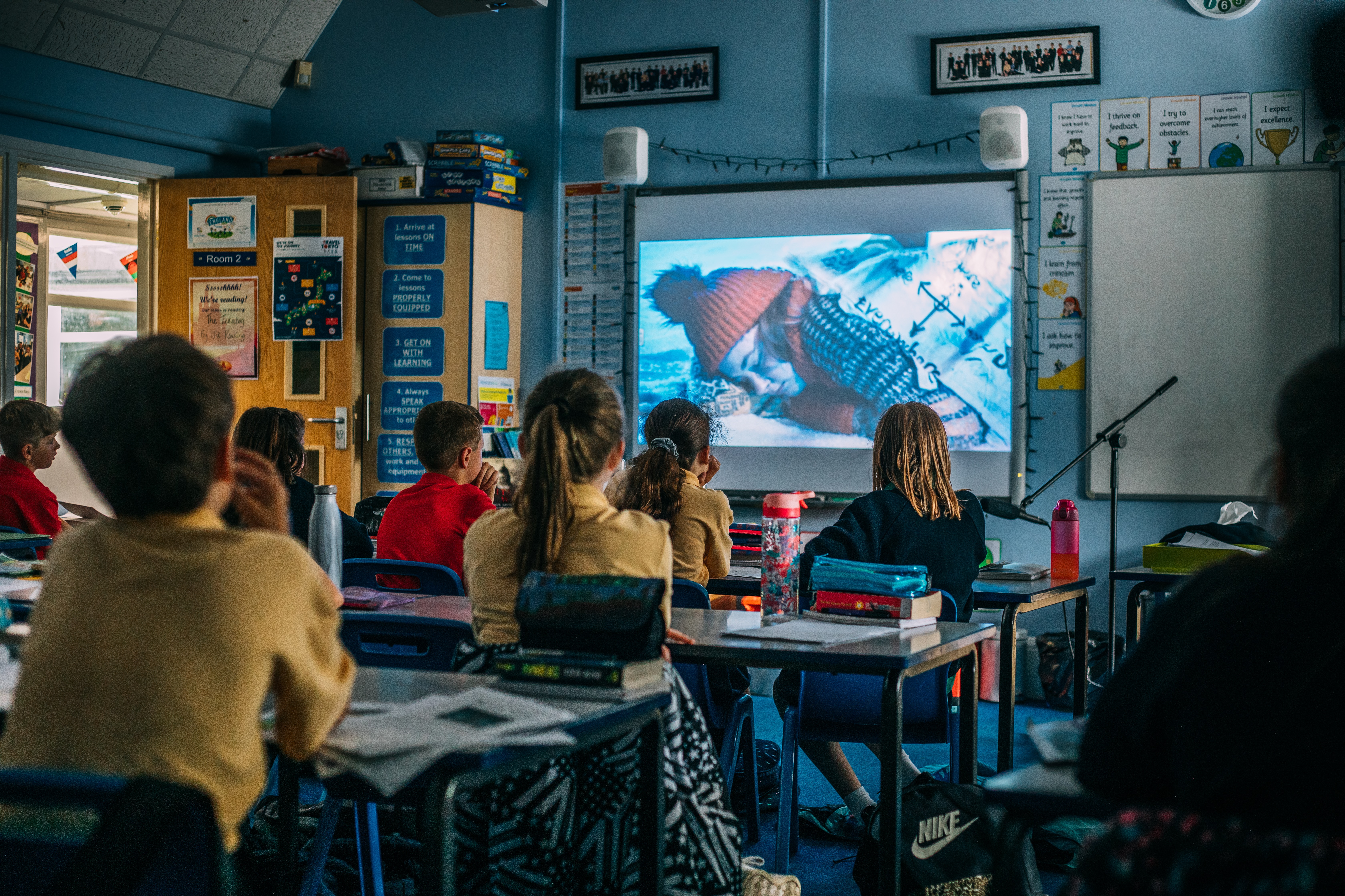 Children in a classroom watching Melva on an interactive board.