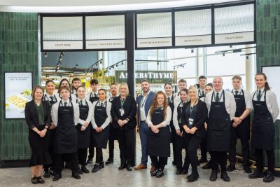 Group shot of Aster and Thyme staff stood at entrance of the restaurant smiling towards the camera.