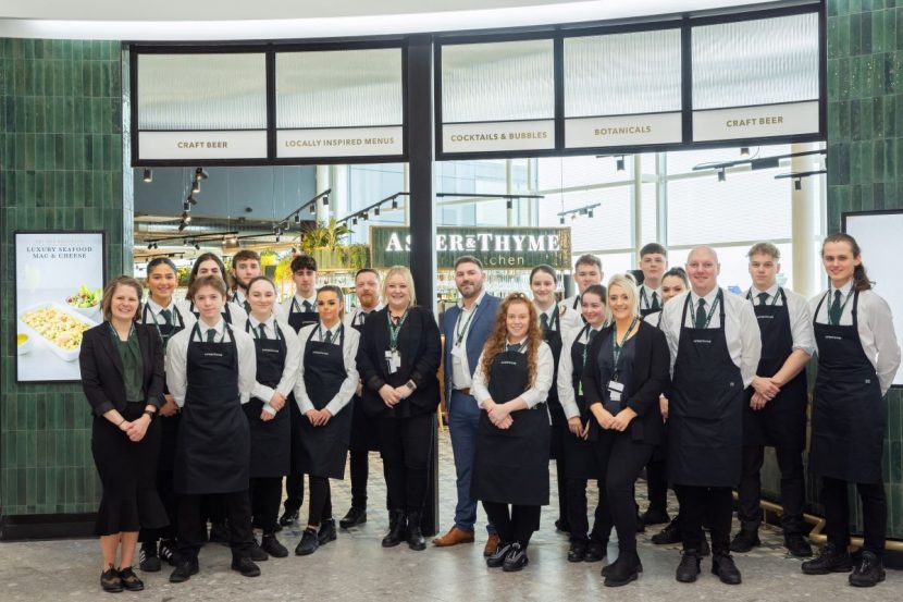 Group shot of Aster and Thyme staff stood at entrance of the restaurant smiling towards the camera.