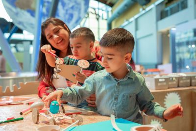 Adult and two children playing with toys at the Centre for Life