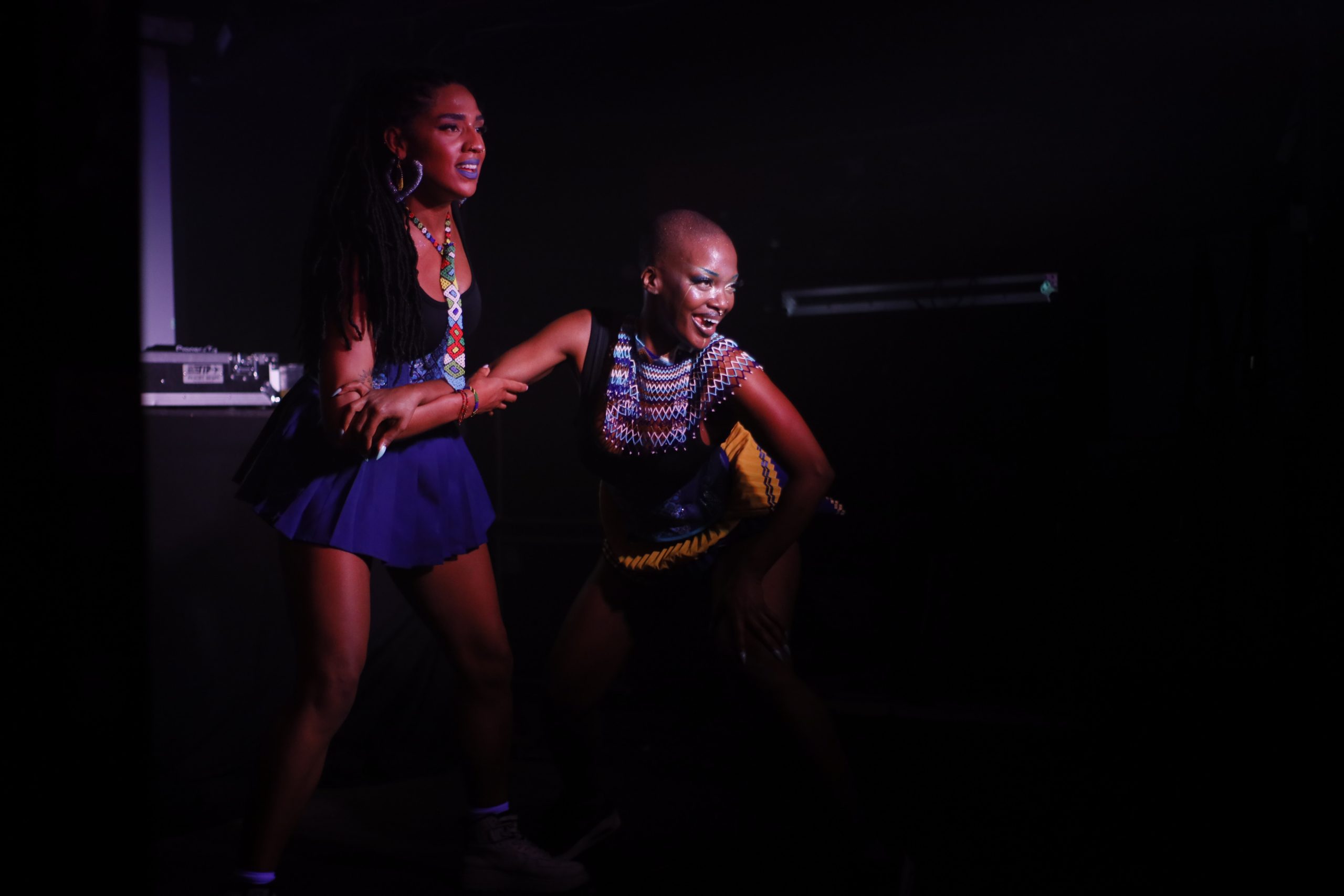 Two performers on stage with a spotlight on them as they look towards the audience.
