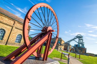Large old-fashioned factory wheel outside of Woodhorn Museum