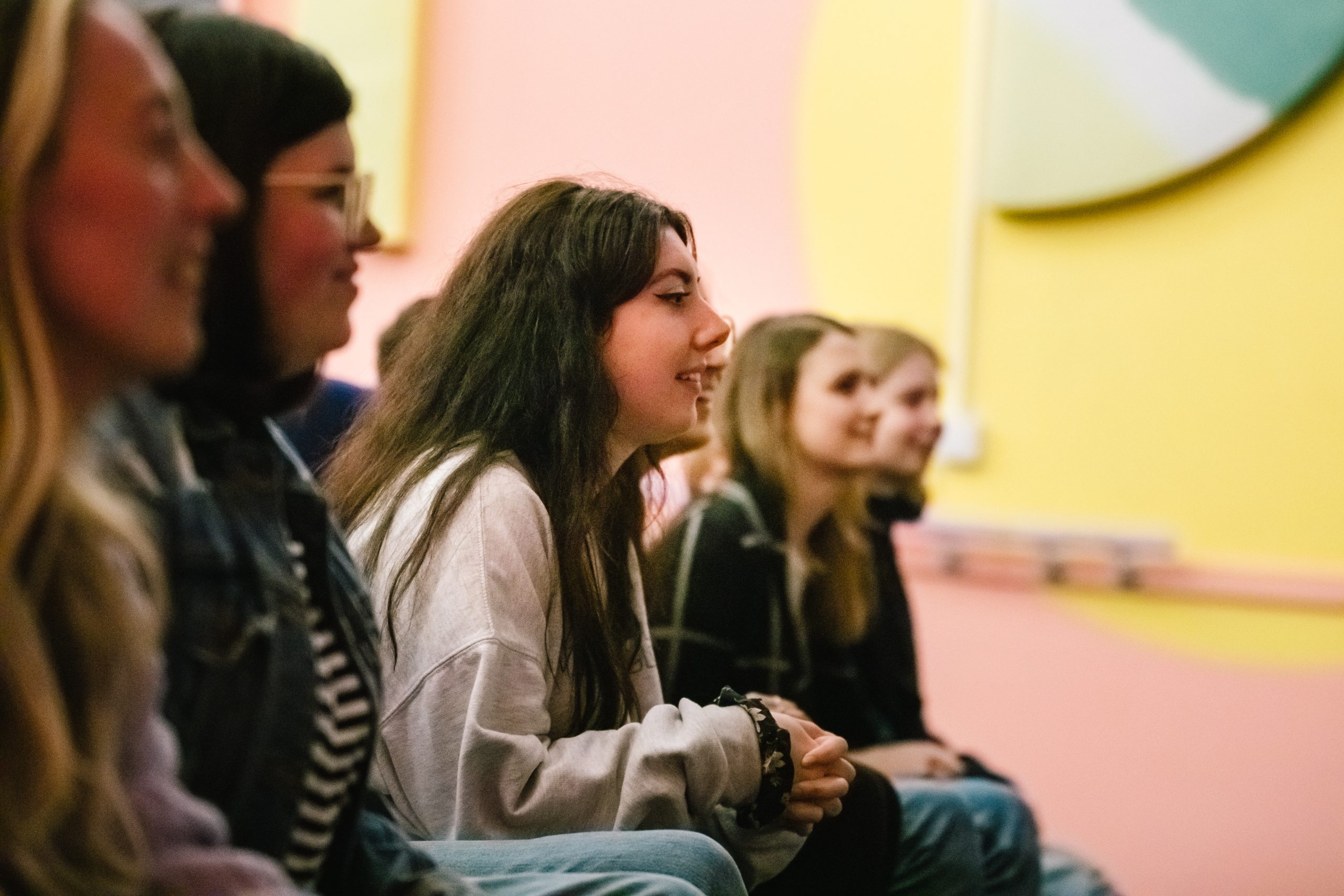 Young people sat in the audience looking to the right of the photo