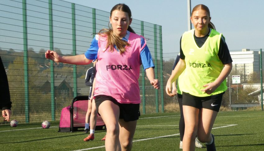 Girls playing football on astroturf