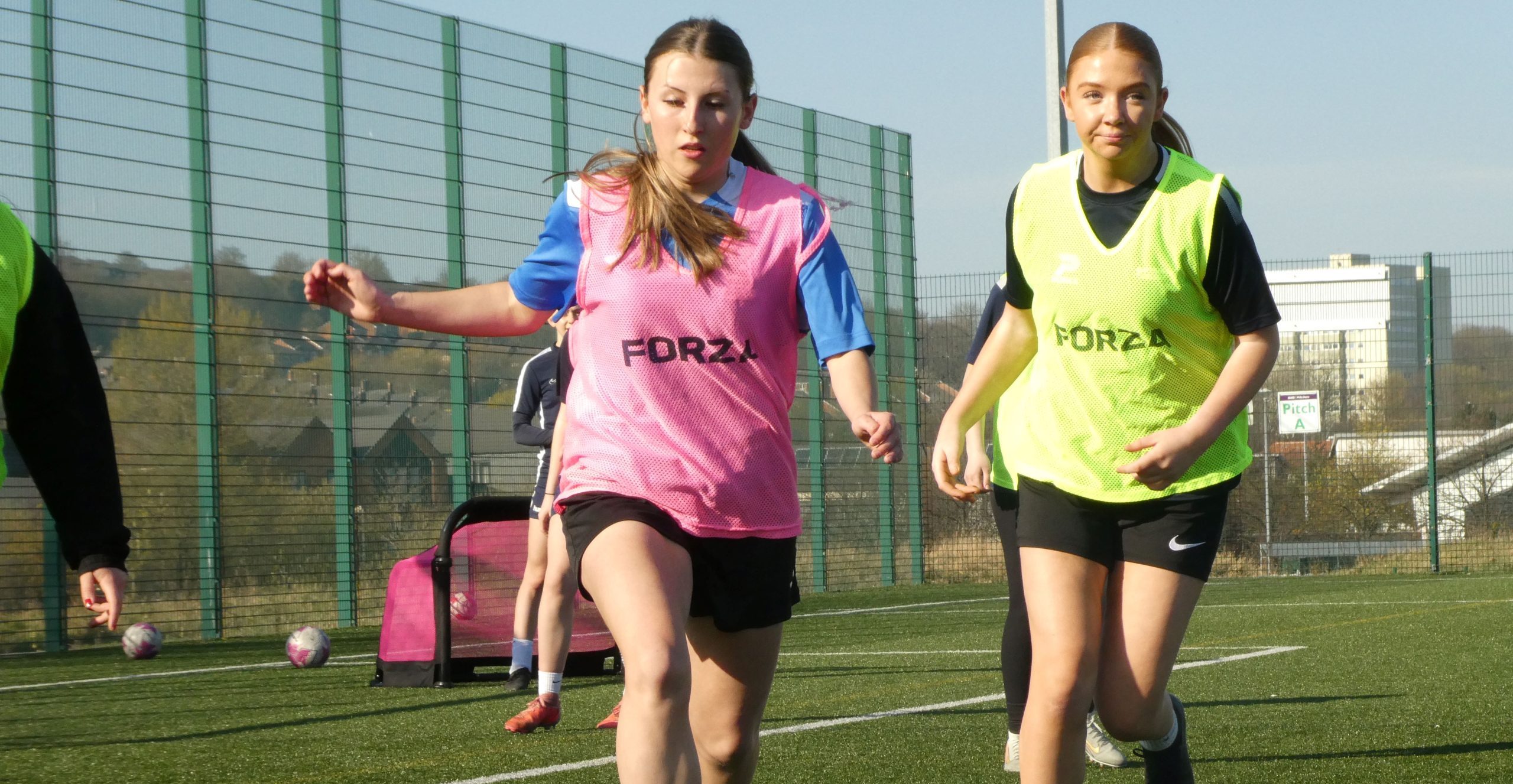 Girls playing football on astroturf