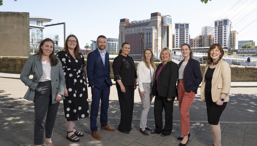 Eight people stood on Newcastle Quayside in business-wear