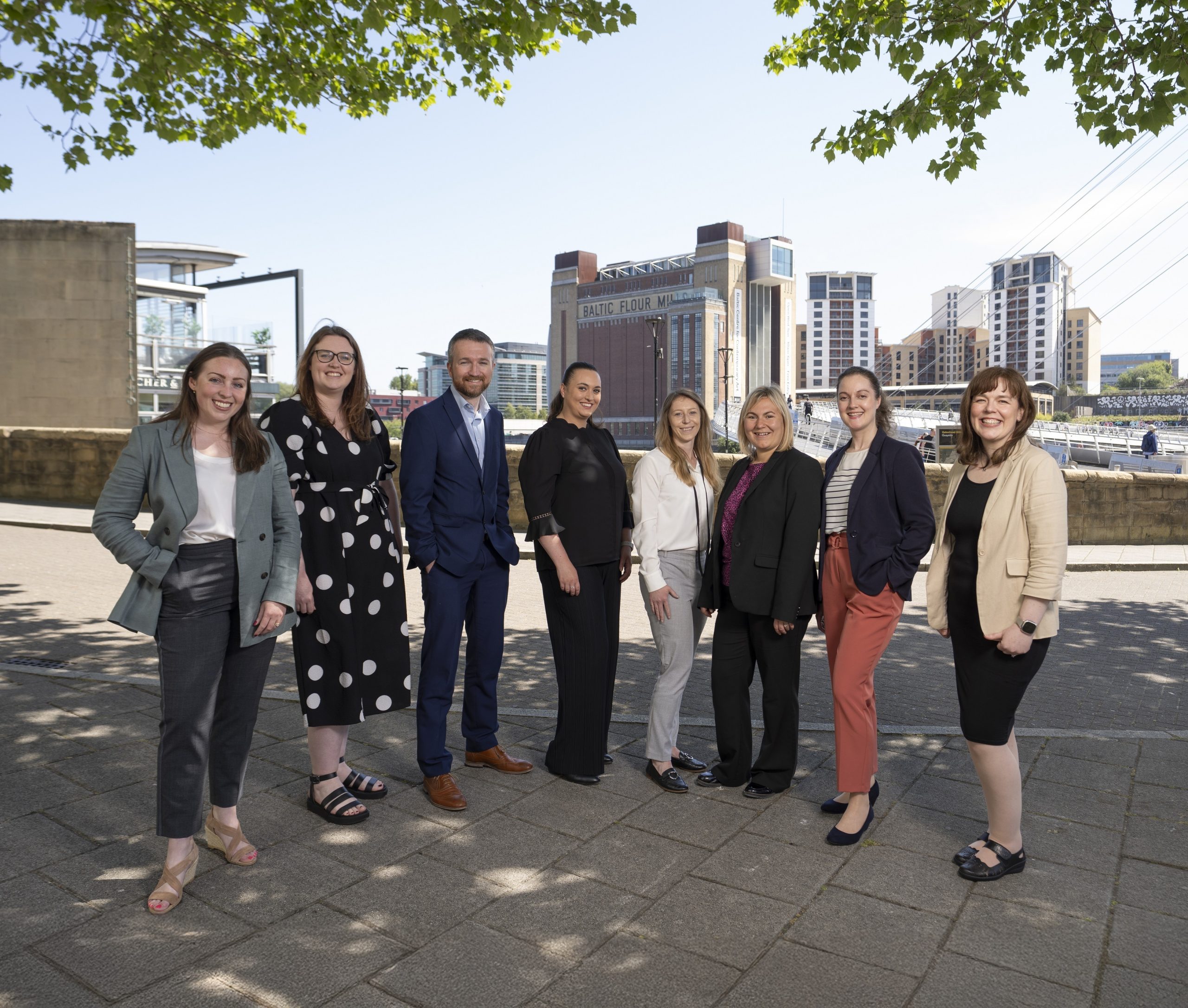 Eight people stood on Newcastle Quayside in business-wear