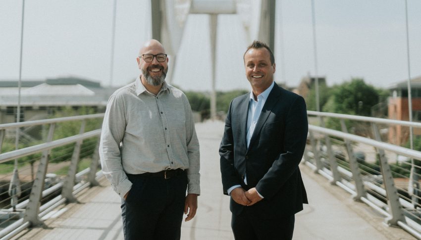 Lee and Steven headshot on a footbridge
