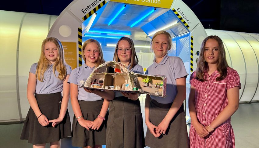 Group of five school children with their science project outside the 'International Space Station' at Centre for Life