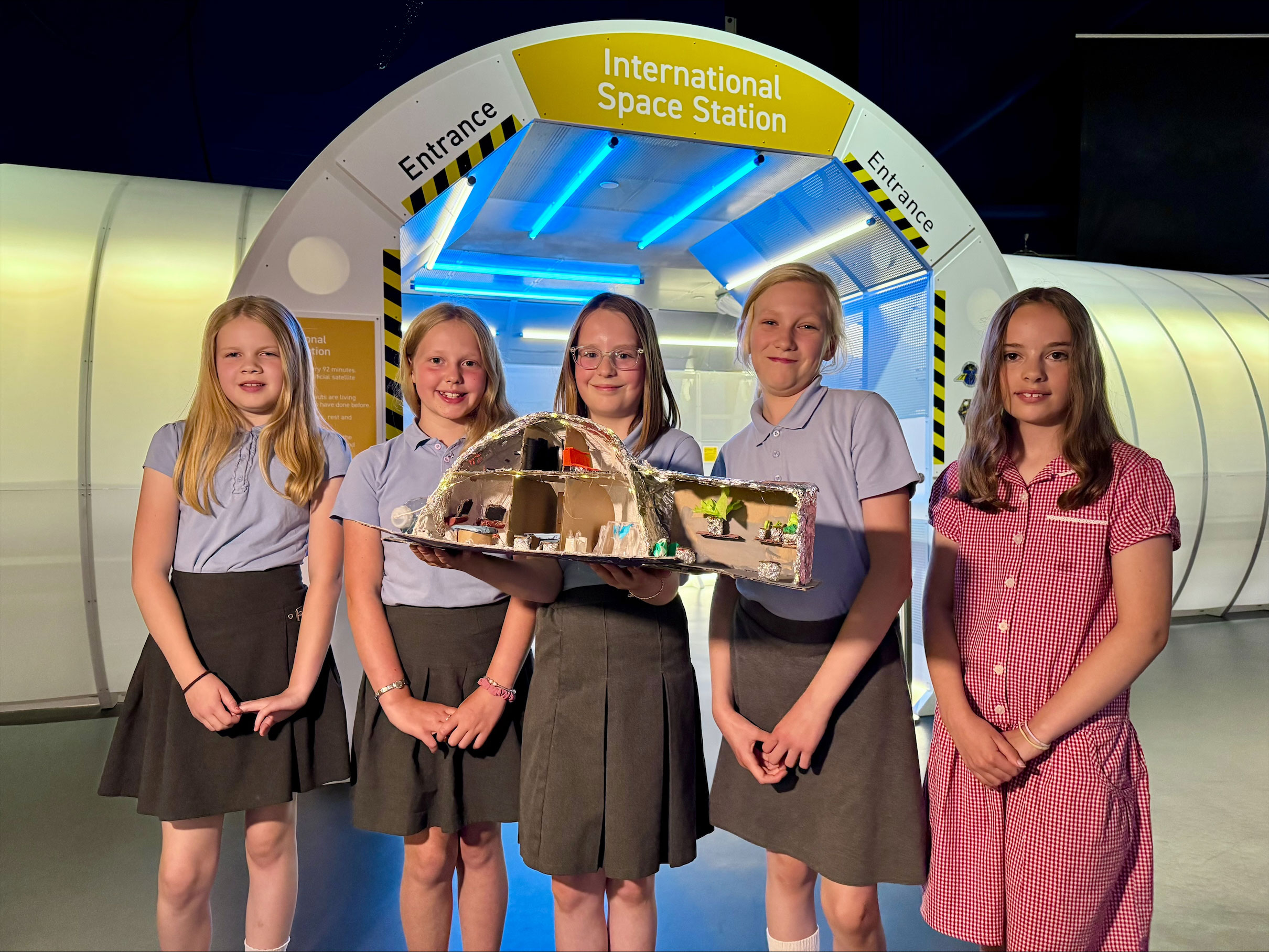 Group of five school children with their science project outside the 'International Space Station' at Centre for Life
