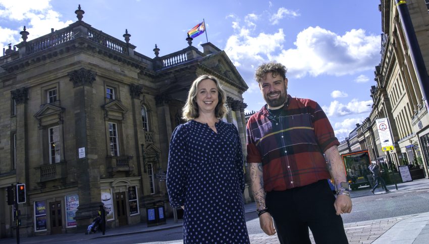 CEO Marianne Locatori and Northern Pride’s Director Ste Dunn stood outside of Theatre Royal where a Pride flag waves from the flag pole on the roof.