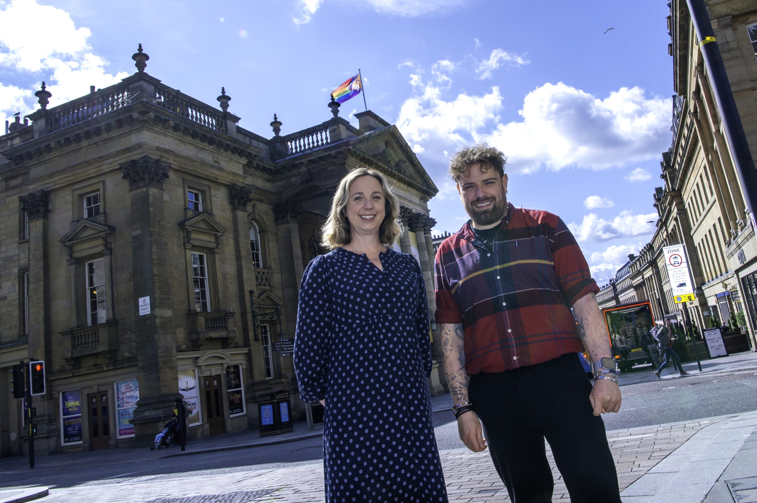 CEO Marianne Locatori and Northern Pride’s Director Ste Dunn stood outside of Theatre Royal where a Pride flag waves from the flag pole on the roof.