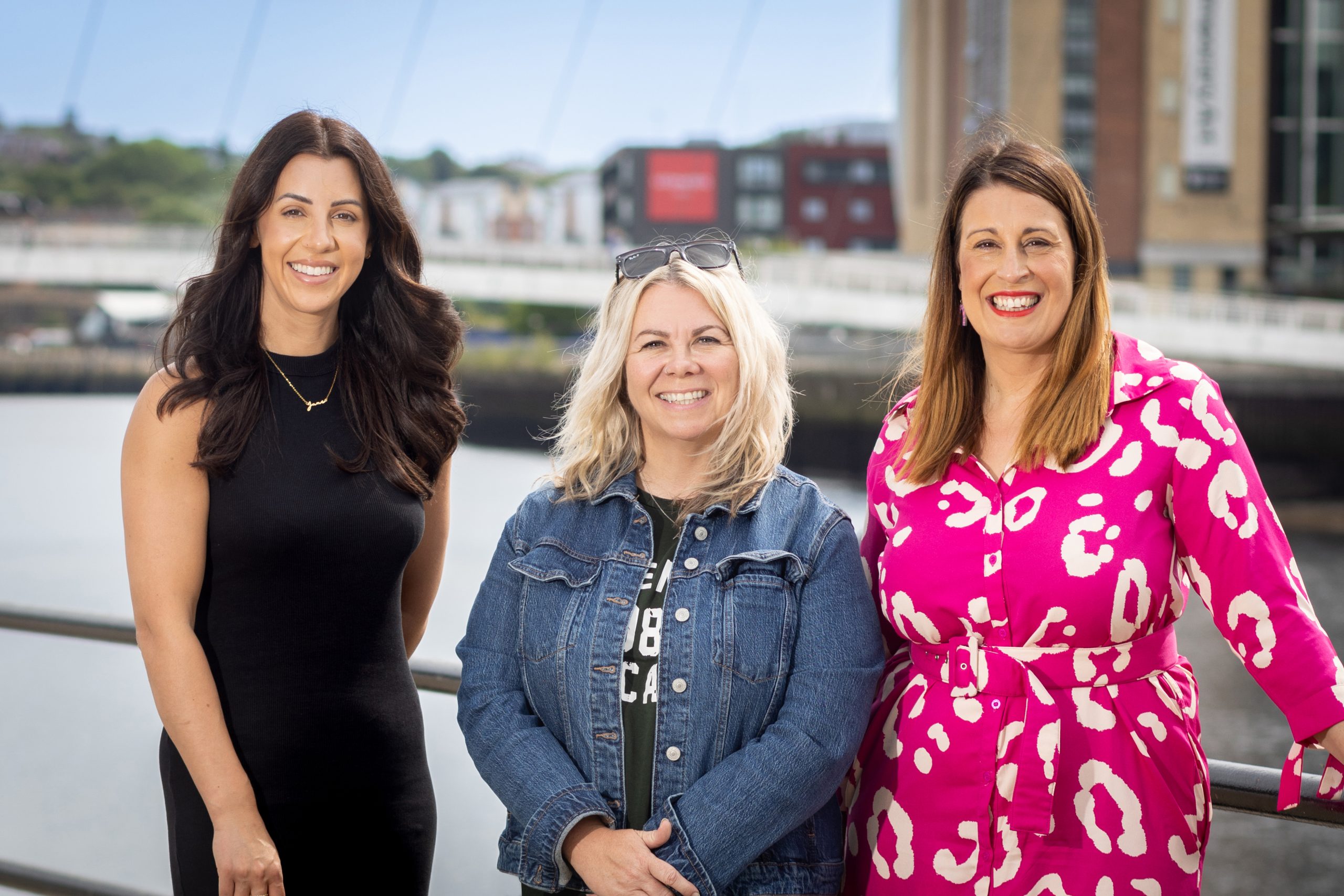 Jen, Angela and Kelly posing for headshots in front of the Millennium Bridge in Newcastle.