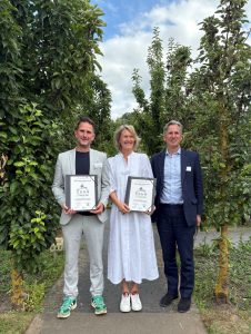 Alistair Baldwin, Lady Barnard and Lord Barnard holding the award up in the Raby Castle gardens.