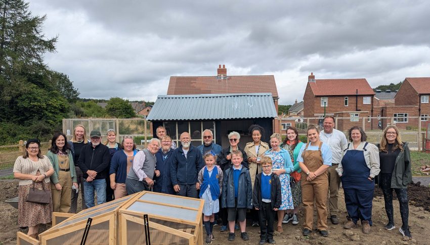 Large group of people smiling together on the Beamish allotments.