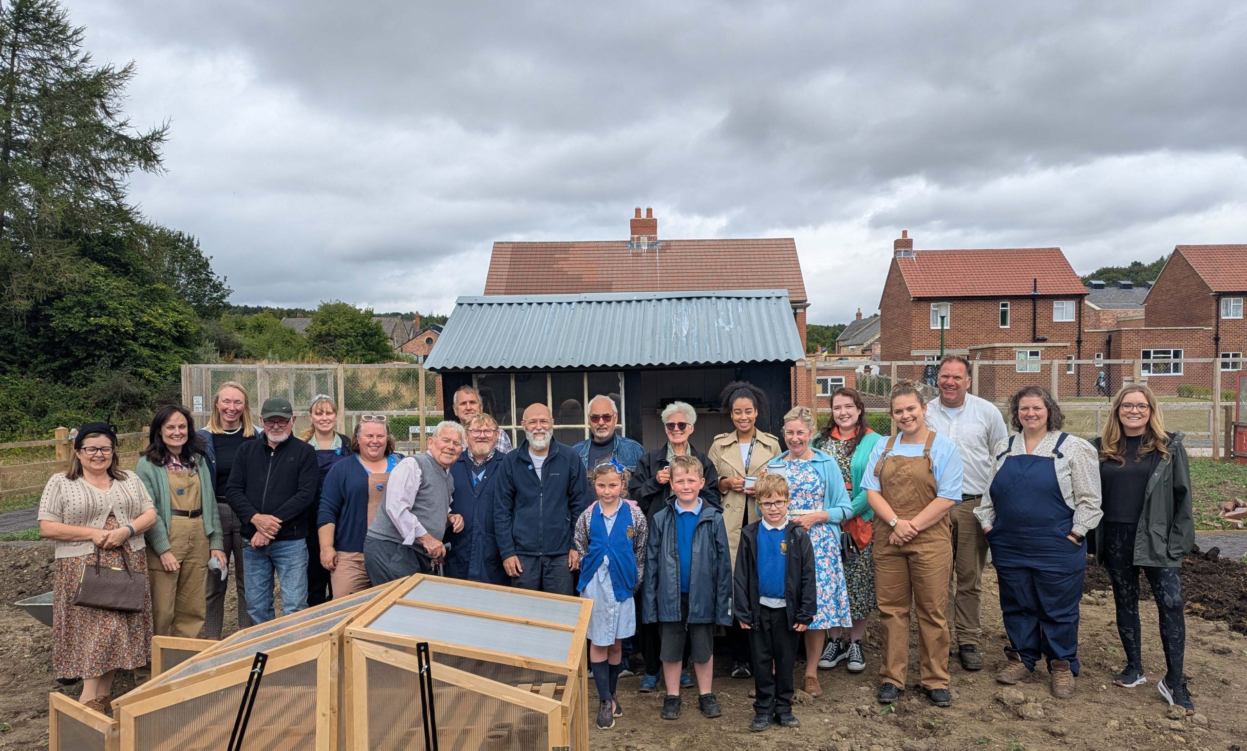 Large group of people smiling together on the Beamish allotments.