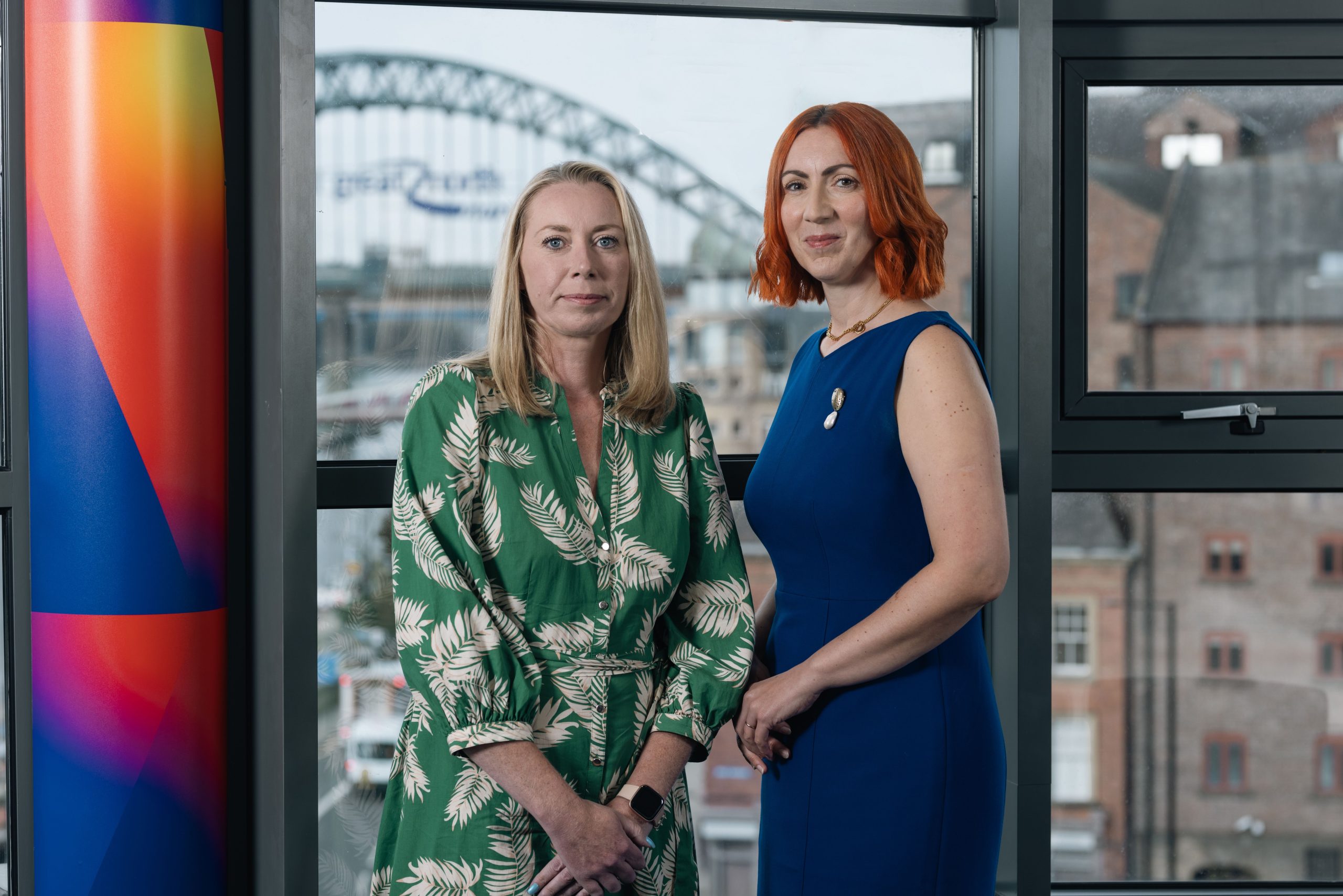 Gemma and Louise in Ward Hadaway office with Tyne Bridge outside the window in the background.
