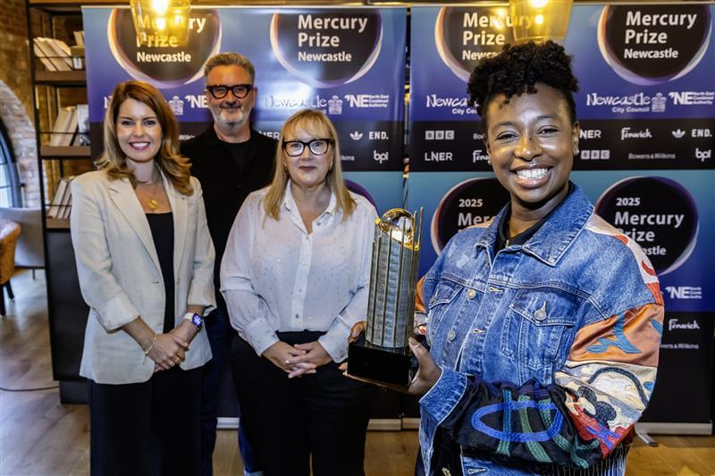 Kim, Gavin, Karen and YolanDa posing with the Mercury Prize award in front of branded backdrop.