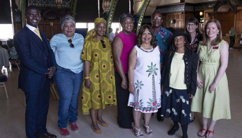 Group of people in brightly coloured and patterned clothes posing together in the Discovery Museum.