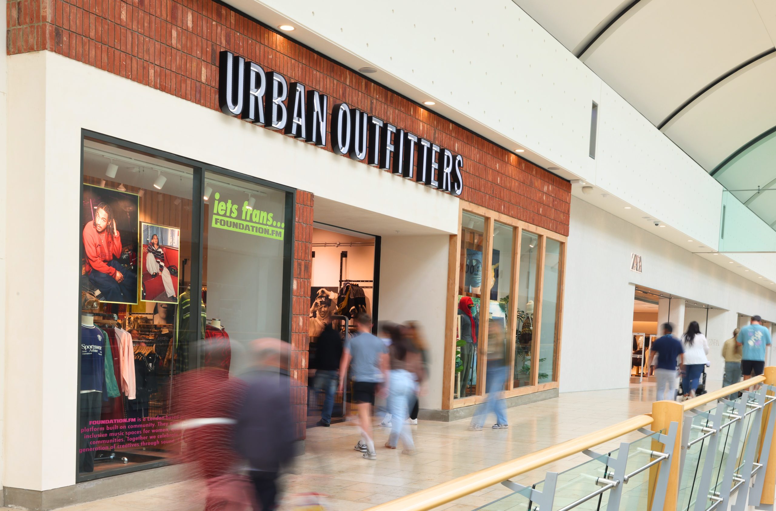 Urban Outfitters shop front in Metrocentre with lots of people walking past and into the store.