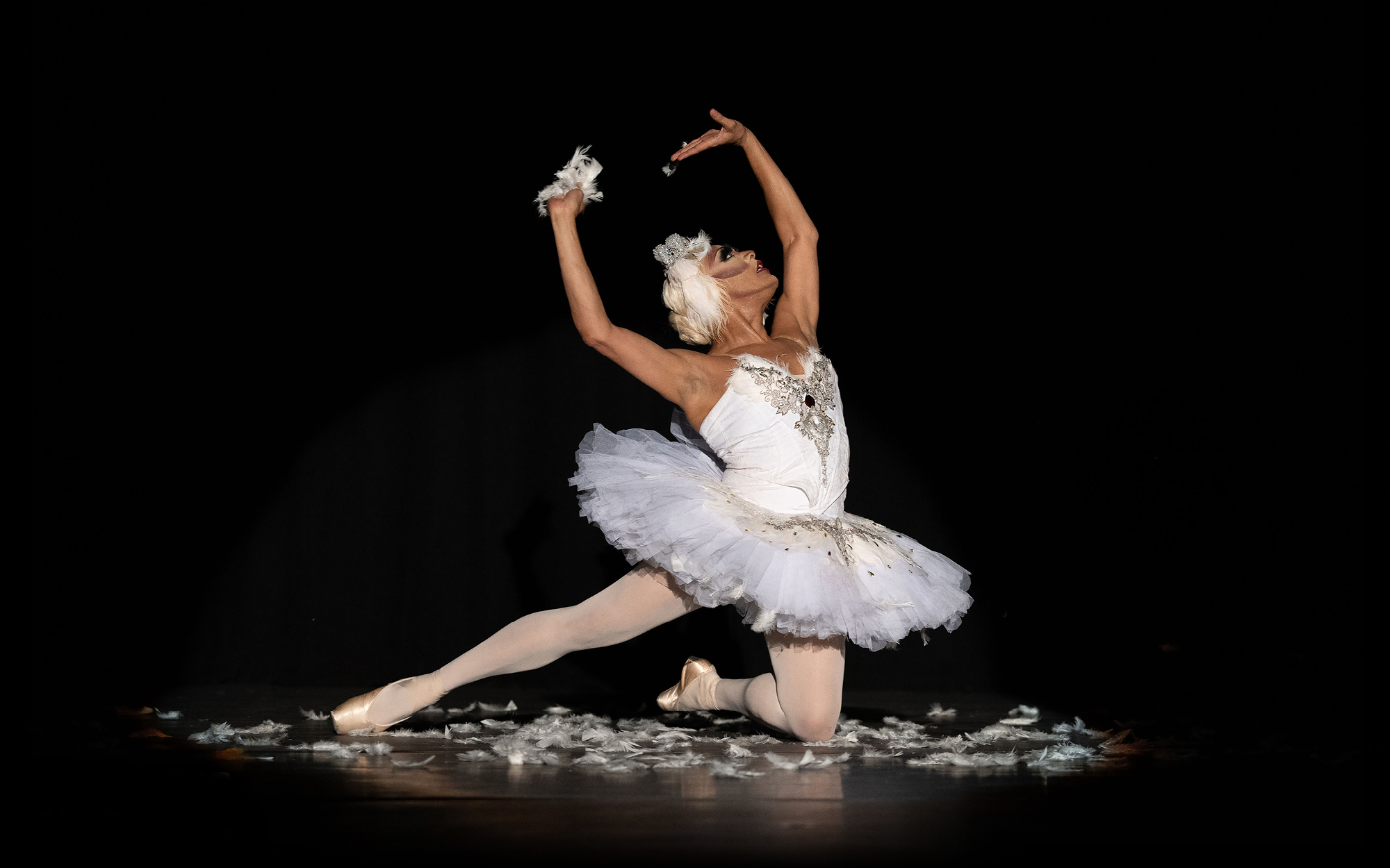 Ballerina performing dramatically on a dark stage