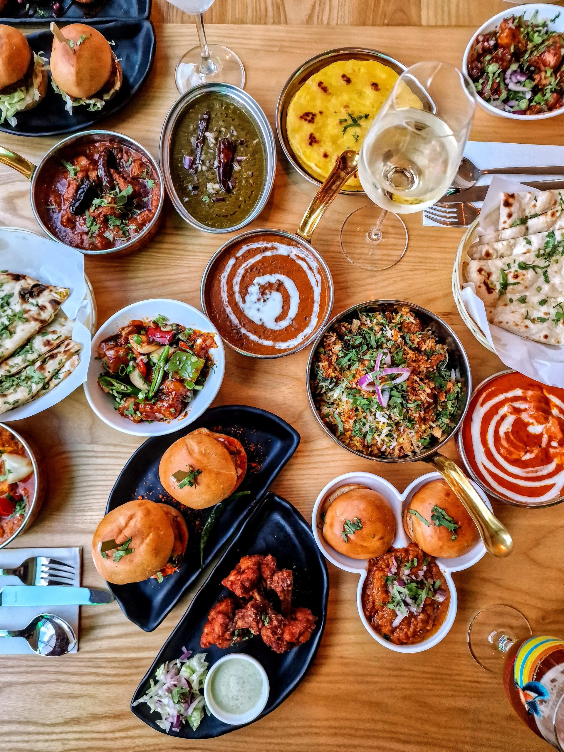 Lots of small plates with food on a wooden table.