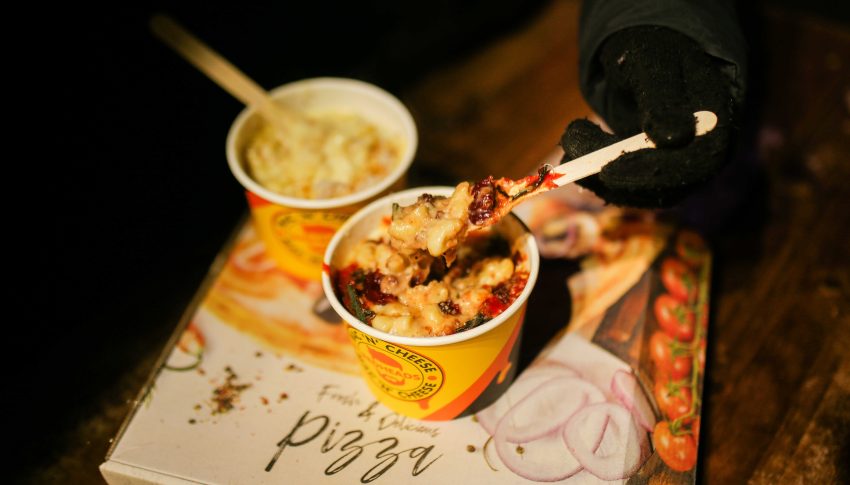 Two bowls of mac n cheese on a table with dramatic lighting.