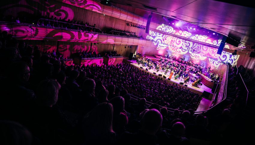Corner view of Sage One hall at The Glasshouse with full audience and orchestra on stage.