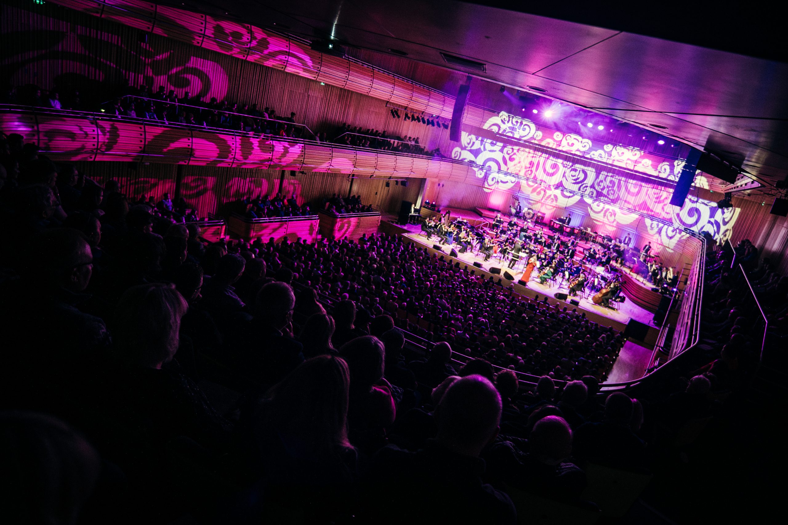 Corner view of Sage One hall at The Glasshouse with full audience and orchestra on stage.