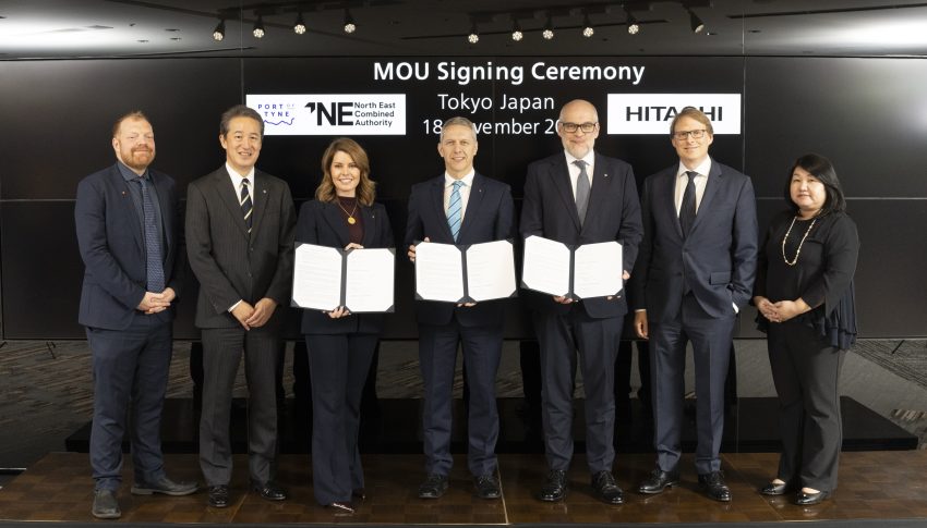 Seven people posing for photo with MoU's in their hands.