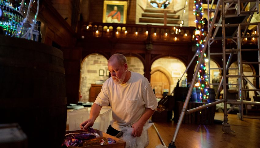 Person decorating a large room in Bamburgh Castle for Christmas
