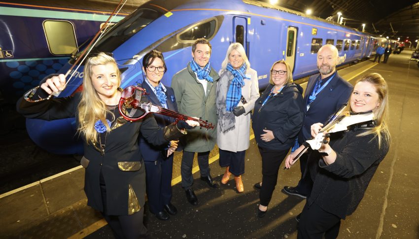 Lumo team standing in front of a blue train.