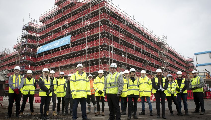 Group of Gateshead College students wearing PPE stood in front of building site.