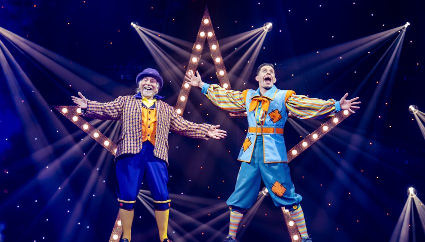 Danny and Clive in Aladdin wearing blue costumes in front of a light star.