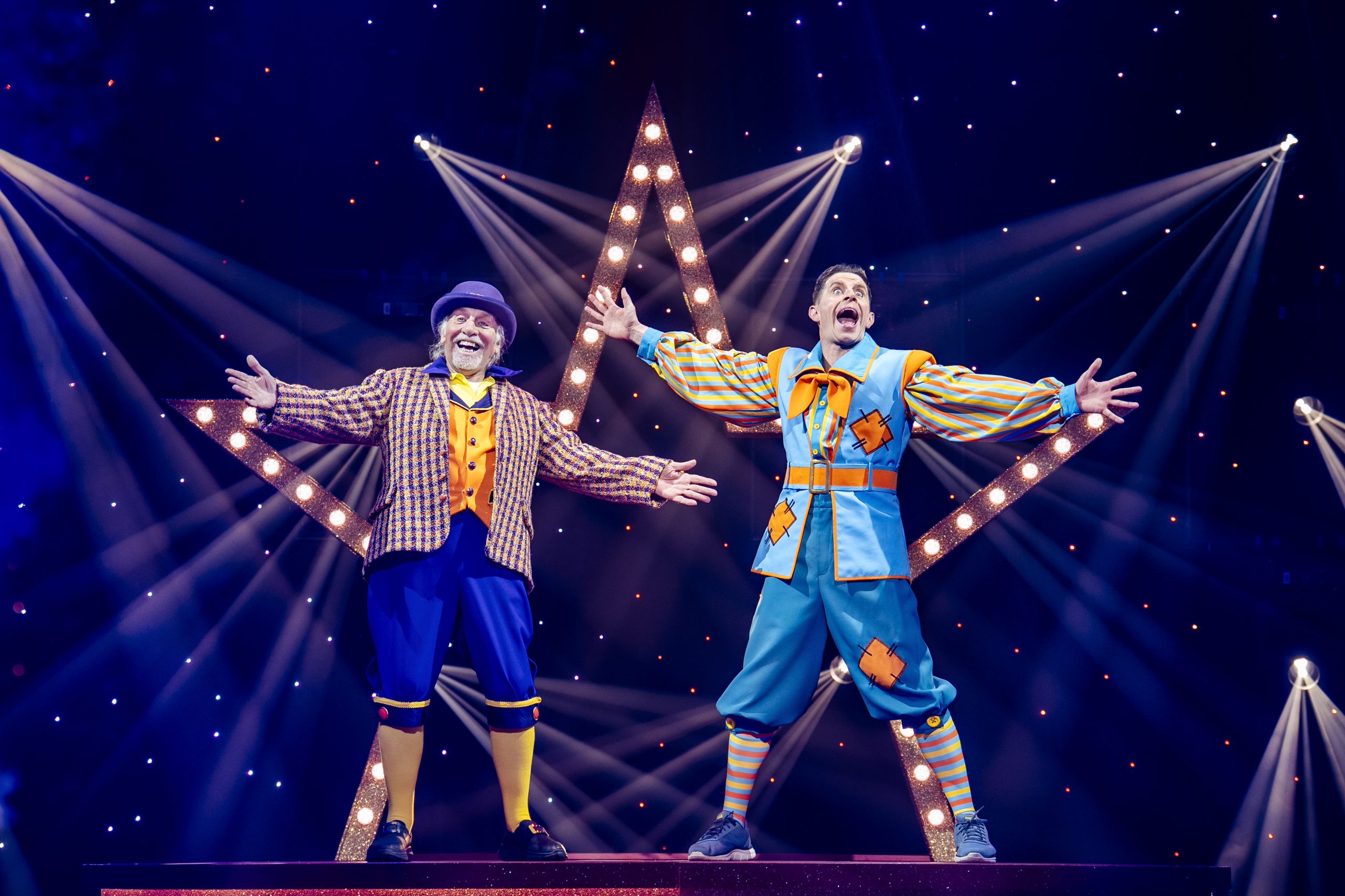 Danny and Clive in Aladdin wearing blue costumes in front of a light star.