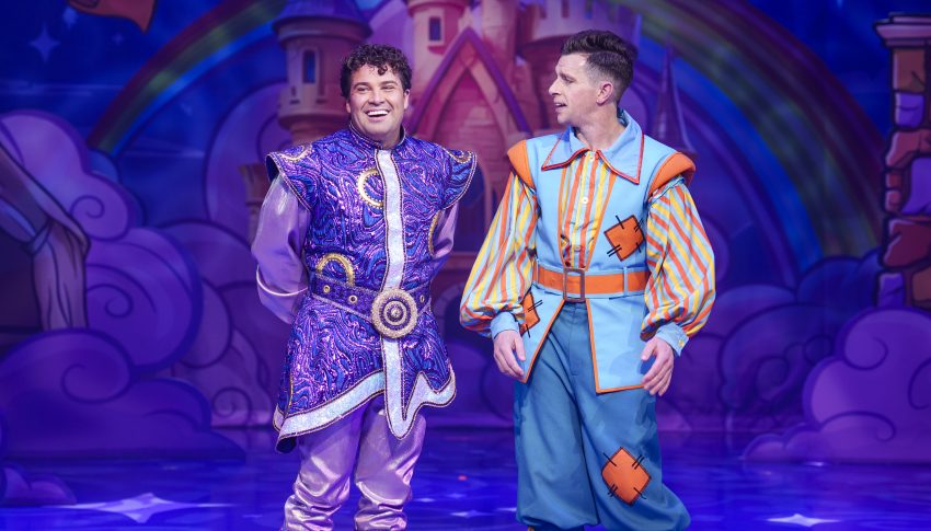 Joe and Danny in full Aladdin costumes on a blue stage.