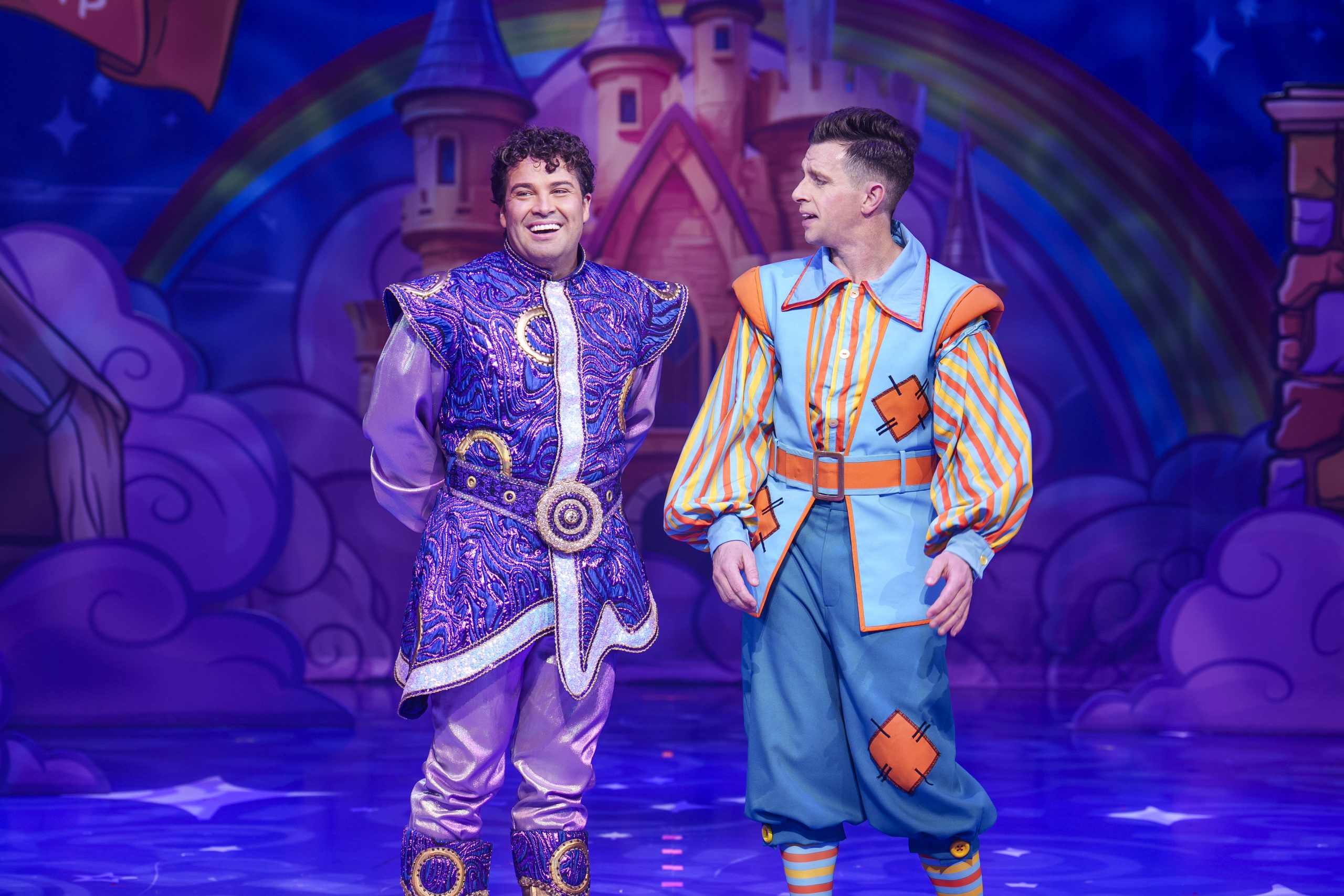 Joe and Danny in full Aladdin costumes on a blue stage.