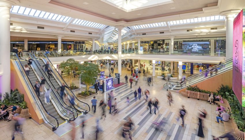 Shoppers in the Metrocentre near escalators.