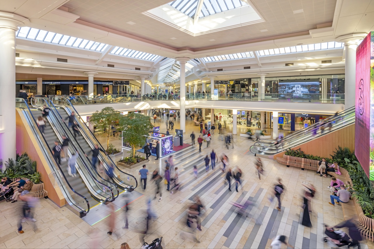 Shoppers in the Metrocentre near escalators.