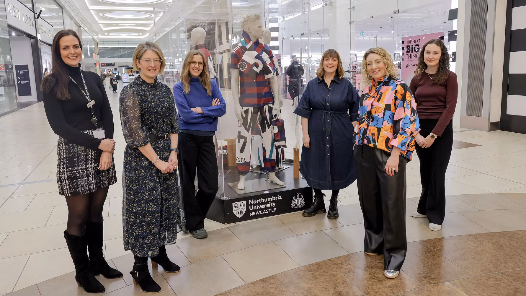A group of women next to a fashion exhibition.
